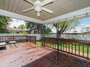 Deck with a lawn, a fenced backyard, and a ceiling fan