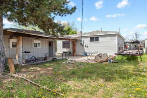 Rear view of property with board and batten siding and a patio area