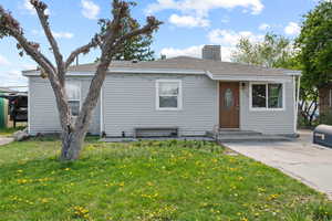 View of front of property featuring a chimney and a front yard