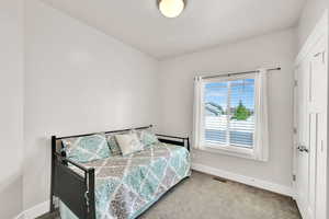 Carpeted bedroom with baseboards and visible vents