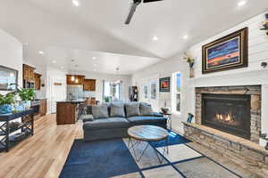 Living room featuring vaulted ceiling, recessed lighting, and light wood-style flooring