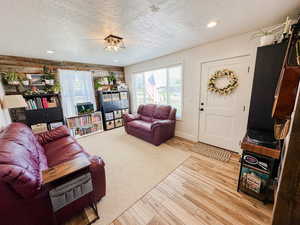 Living area featuring recessed lighting, light wood finished floors, and a textured ceiling