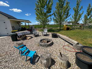 View of yard with an outdoor fire pit and fence