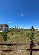 View of yard with fence and a rural view