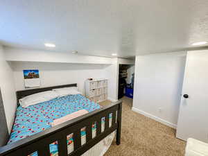 Bedroom with baseboards, carpet, a textured ceiling, and recessed lighting