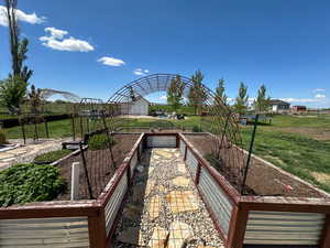 View of property's community featuring a lawn and a vegetable garden