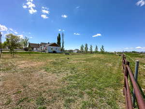 View of yard featuring a rural view and fence