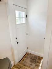 Doorway to outside with baseboards and wood finished floors