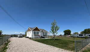 View of front of home with fence, driveway, and a front lawn