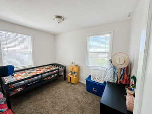 Carpeted bedroom with baseboards and a textured ceiling