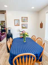 Dining space with recessed lighting, light wood finished floors, and a textured ceiling