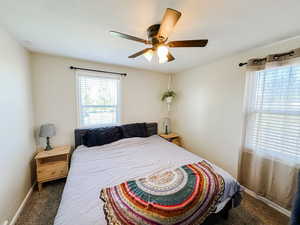 Carpeted bedroom featuring baseboards and a ceiling fan
