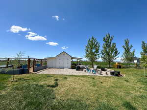 View of yard featuring fence, an outdoor structure, a garden, and a shed