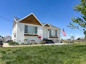 View of front of home with a front lawn and stucco siding