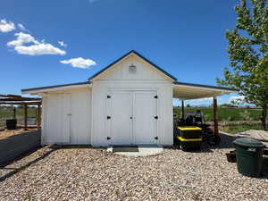 View of shed featuring fence and cooling unit