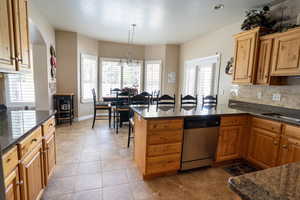 Kitchen featuring plenty of natural light, stainless steel dishwasher, backsplash.