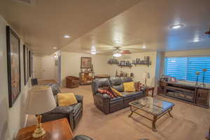 Carpeted living area with recessed lighting, a ceiling fan, a textured ceiling, and baseboards