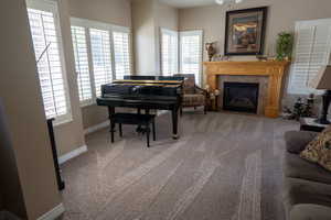 Sitting room featuring baseboards, carpet floors, and a tile fireplace
