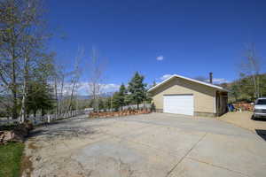 View of property exterior with fence and a garage