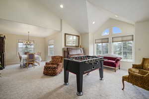 Recreation room with baseboards, a notable chandelier, a healthy amount of sunlight, and carpet
