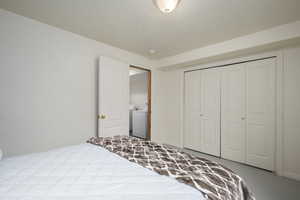 Bedroom featuring a closet, a textured ceiling, and washer / dryer
