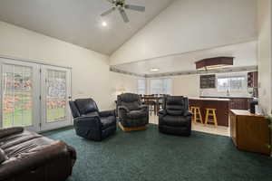 Living room with dark carpet, recessed lighting, ceiling fan, and high vaulted ceiling