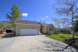 Single story home featuring a garage, a front lawn, fence, brick siding, and driveway