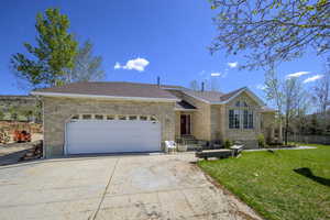 Ranch-style house featuring brick siding, driveway, a front yard, and a garage