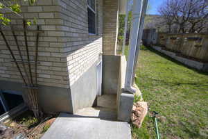 View of side of home with fence and brick siding
