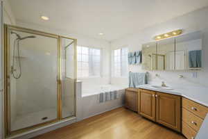 Bathroom with vanity, wood finished floors, recessed lighting, a bath, and a shower stall