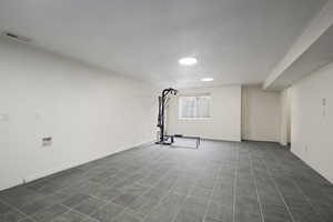 Exercise room featuring recessed lighting, visible vents, and dark tile patterned floors