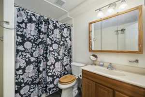 Full bath with vanity, toilet, tile patterned floors, a shower with curtain, and visible vents