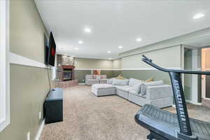 Living room featuring carpet floors, recessed lighting, baseboards, and a large fireplace