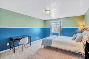 Carpeted bedroom with baseboards and a textured ceiling