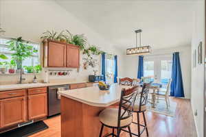 Kitchen featuring french doors, a sink, light countertops, light wood-style floors, and stainless steel appliances