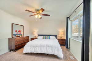 Bedroom with visible vents, a ceiling fan, carpet, and baseboards