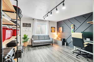 Office space featuring baseboards, a textured ceiling, and wood finished floors