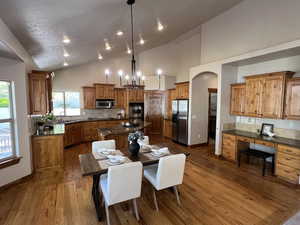 Kitchen with decorative backsplash, brown cabinetry, a center island, a sink, and stainless steel appliances