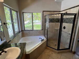 Bathroom featuring a sink, a bath, a healthy amount of sunlight, and a shower stall