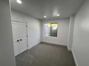 Empty room featuring dark colored carpet, recessed lighting, baseboards, and visible vents