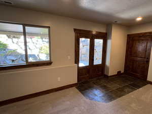 Foyer featuring baseboards, visible vents, and a healthy amount of sunlight