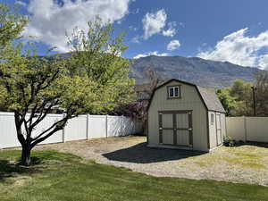 View of shed with a fenced backyard and a mountain view