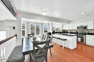 Dining room featuring light wood-style flooring, recessed lighting, and a textured ceiling