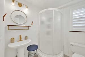 Full bath featuring toilet and a shower stall