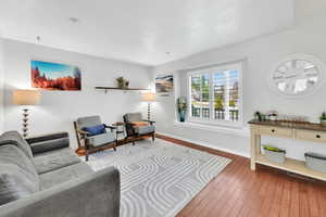 Living room featuring baseboards, a textured ceiling, wood-type flooring, and visible vents