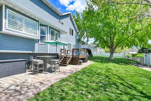 View of yard featuring fence, a wooden deck, and a patio