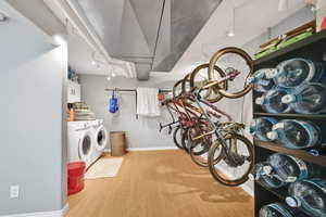 Interior space with independent washer and dryer, baseboards, wood finished floors, and laundry area