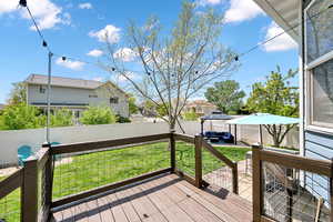 Wooden deck with a gazebo, a fenced backyard, outdoor lounge area, and a yard