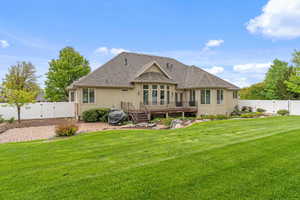 Rear view of house featuring a deck, a gate, a fenced backyard, a yard, and stucco siding