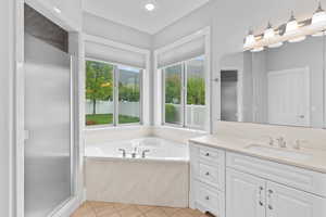 Bathroom with vanity, a stall shower, tile patterned floors, and a bath